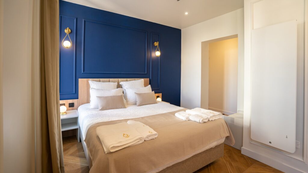 Chambre lit double aux tons froids avec du bleu marine, aménagée par Fournimob.