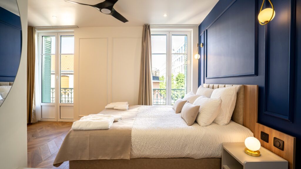 Chambre lit double aux tons froids avec du bleu marine, aménagée par Fournimob.
